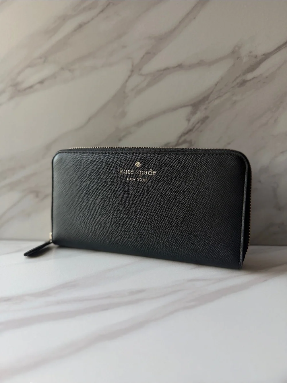 Kate Spade black saffiano leather zip-around continental wallet.